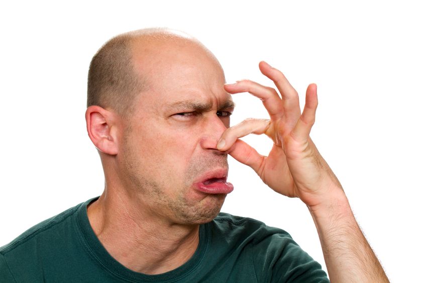 man holding his nose due to urine smell